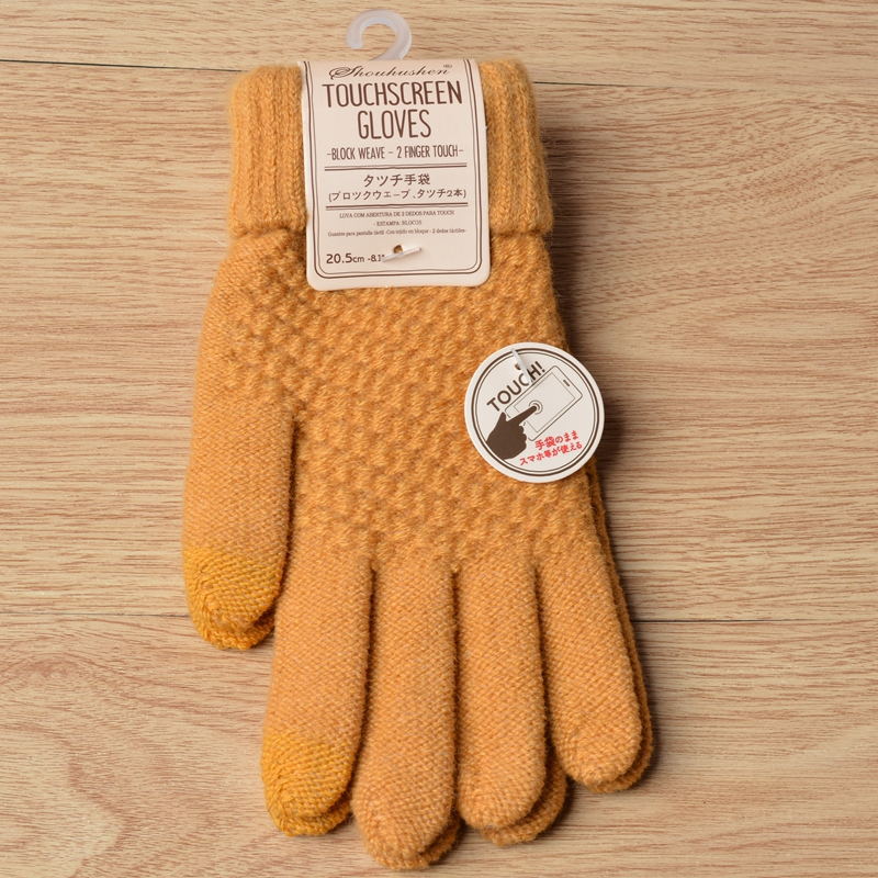 Pair of mustard yellow touchscreen gloves with a label on a wooden surface