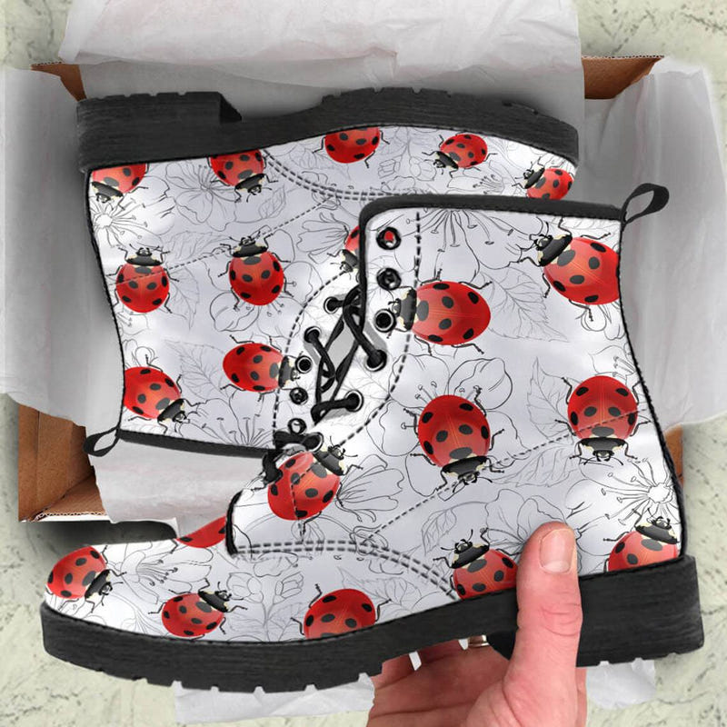 Ladybug print combat boots with black lace-up shaft and chunky sole, shown in box