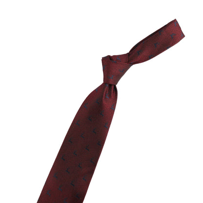 Maroon tie with black patterns and a gold violin-shaped accessory on a white background