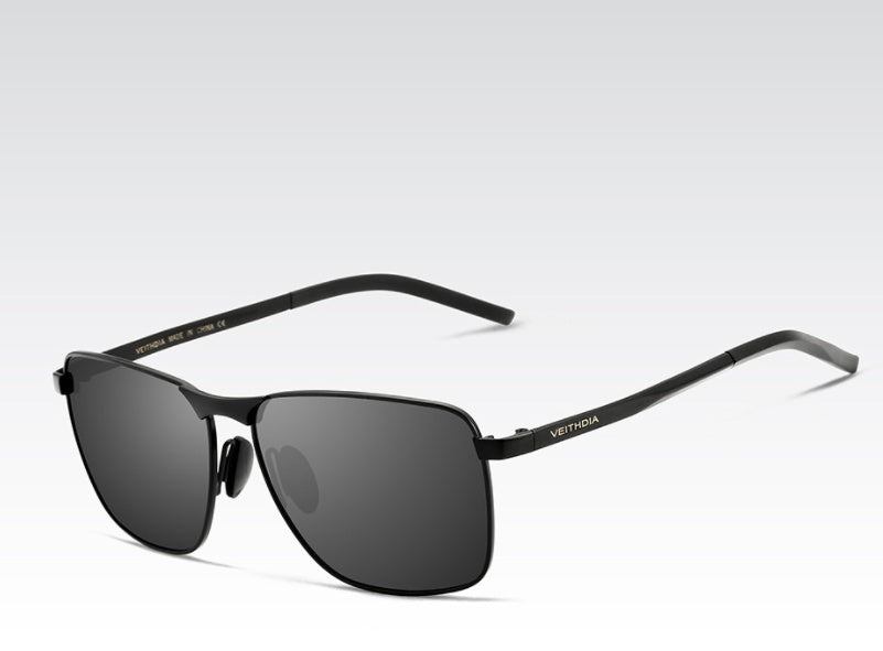 Black sunglasses with a visible brand logo on a light gray background