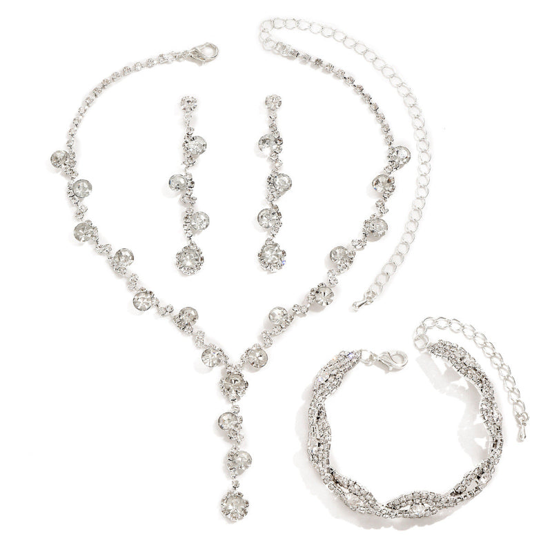 Silver jewelry set including necklace, bracelet, and earrings on a white background