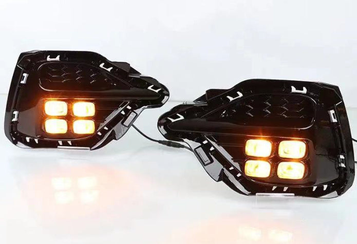Pair of motorcycle fog lights with amber LEDs on a white background