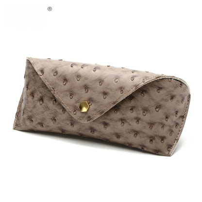 Brown textured clutch bag with a gold clasp on a white background