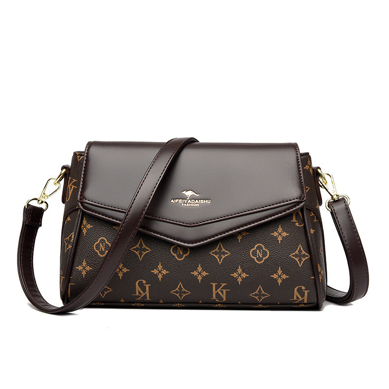 Brown handbag with gold monogram pattern on a white background
