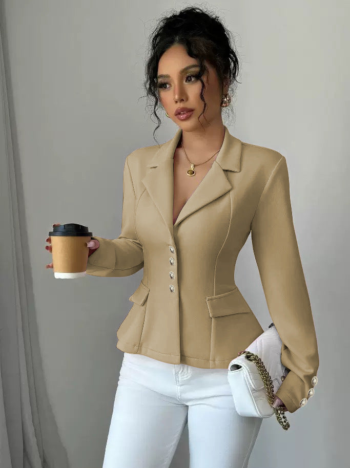 Woman in a beige blazer holding a coffee cup and a white handbag against a neutral background