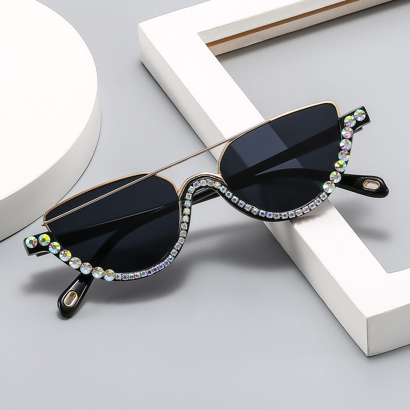 Cat-eye sunglasses with gold frame, dark blue lenses, and multicolor rhinestone border
