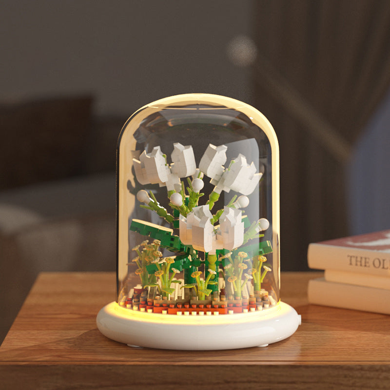 Decorative night light with floral design inside a glass dome on a wooden surface.