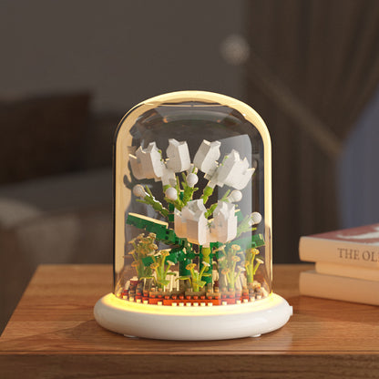 Decorative night light with floral design inside a glass dome on a wooden surface.
