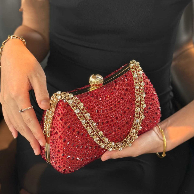 Wine red rhinestone clutch handbag with gold-tone chain strap and rounded kisslock frame.