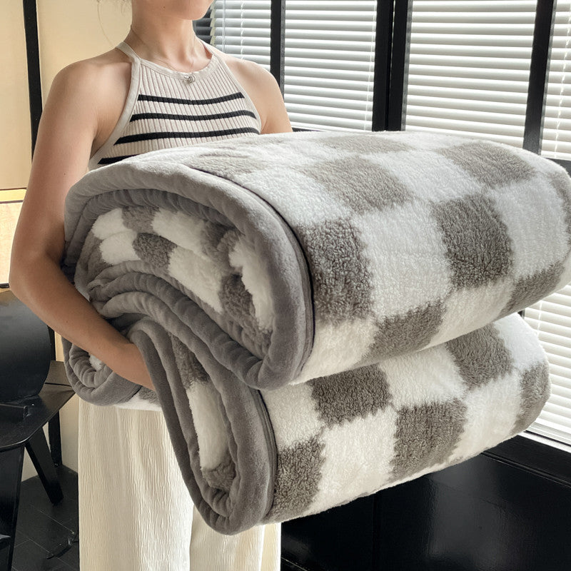 Person holding a checkered blanket in an indoor setting