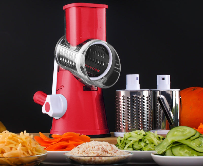 Red manual food grinder with various sliced vegetables on a dark background