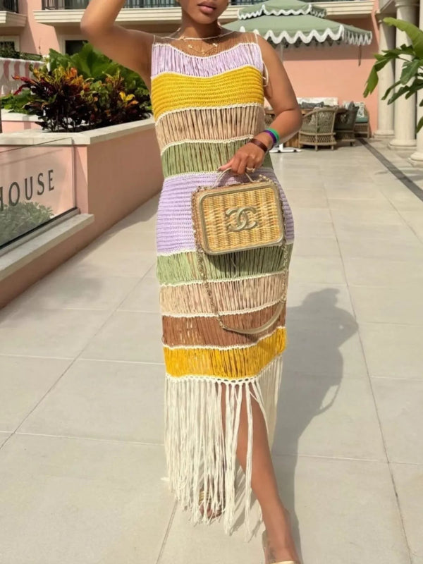 Woman wearing a colorful striped dress with fringe holding a woven handbag.