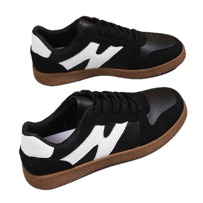 Women's low-top color-block sneakers, black with white side panels and tan gum outsole.