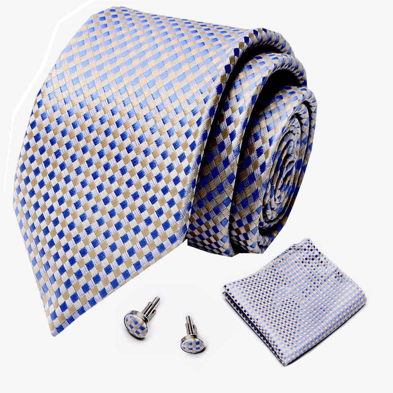 Blue and beige checkered tie with matching pocket square and cufflinks on a white background