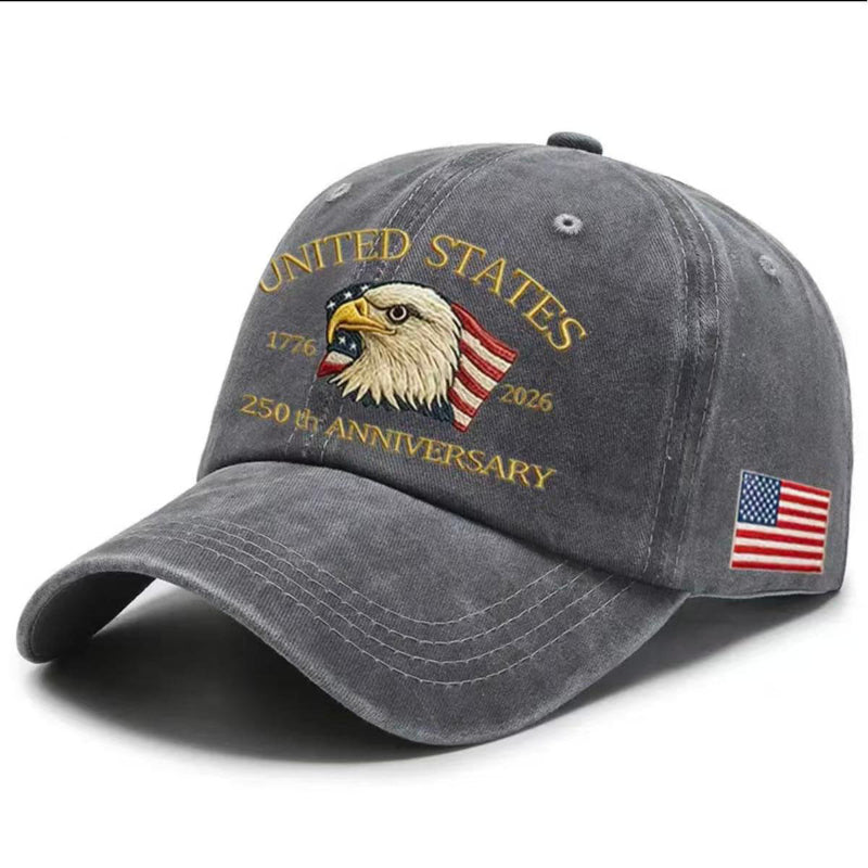 Dark gray washed-print cap with gold “United States 1776–2026” eagle graphic and flag patch.