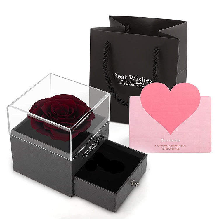 Black gift box with a red rose, black card, and pink heart-shaped card on a white background