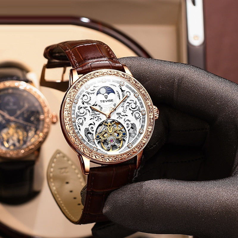 Luxury watch with brown leather strap held by a gloved hand, brand 'Tevise' visible