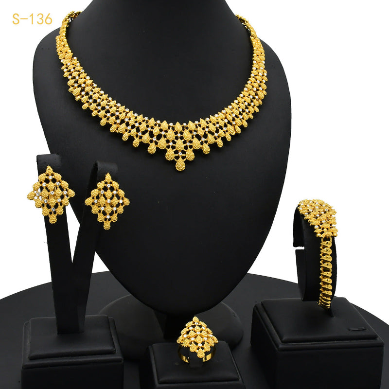 Gold necklace, earrings, and bangles set on a black mannequin