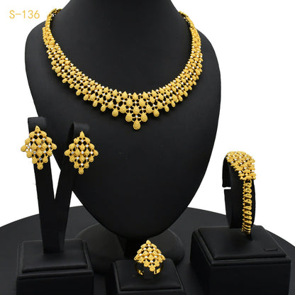 Gold necklace, earrings, and bangles set on a black mannequin