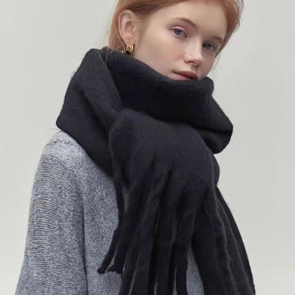 Person wearing a black scarf with a plain background