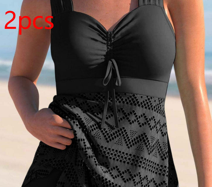 Black two-piece swimsuit with geometric patterned bottom on a beach.