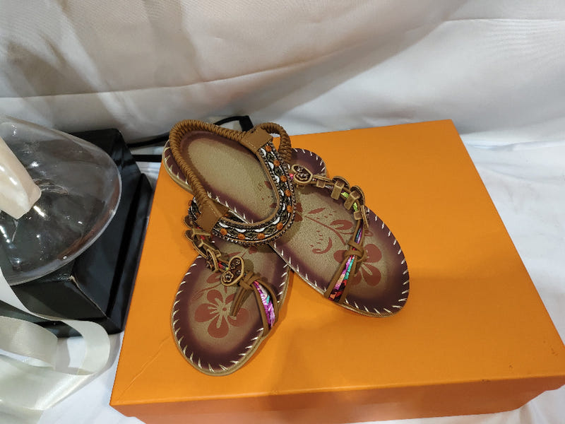 Women’s ethnic beaded sandals with rhinestone trim, shown in orange shoe box.