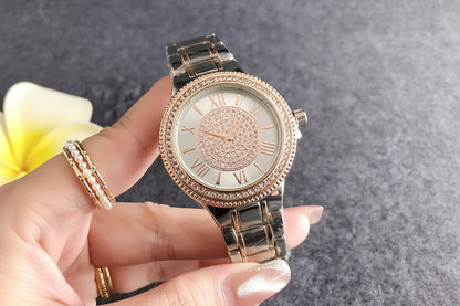 Rose gold watch with diamond accents held by a hand, against a Guess branded box.