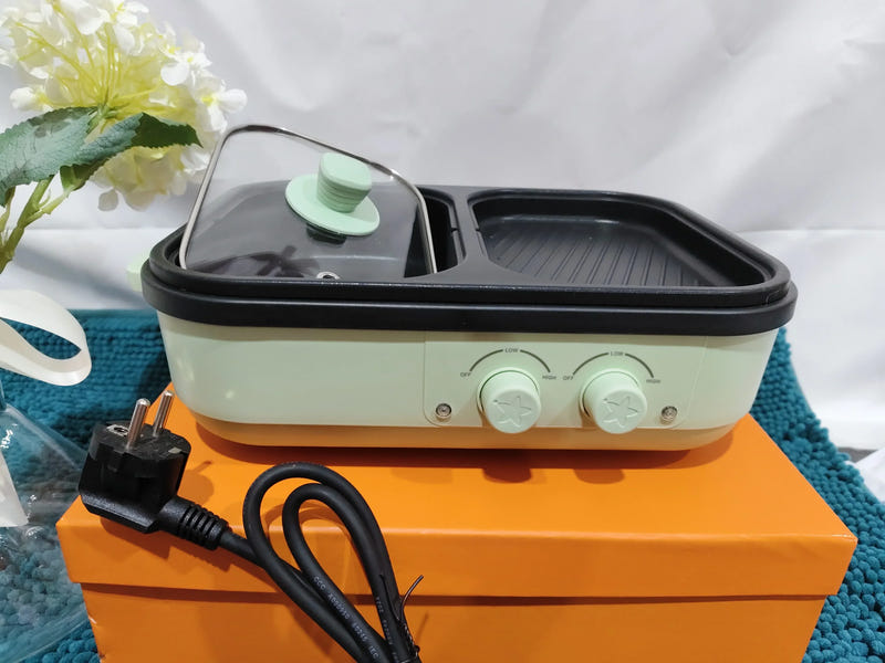 Light green electric cooking pot with lid, two control knobs, and power cable