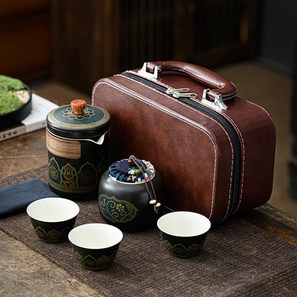 Tea set with a brown leather suitcase on a wooden surface