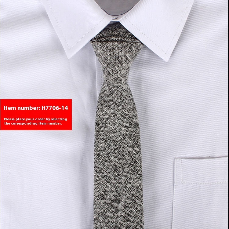 Gray patterned tie on a white shirt with a red item number label.