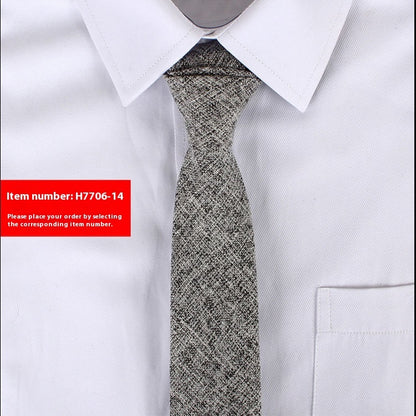 Gray patterned tie on a white shirt with a red item number label.