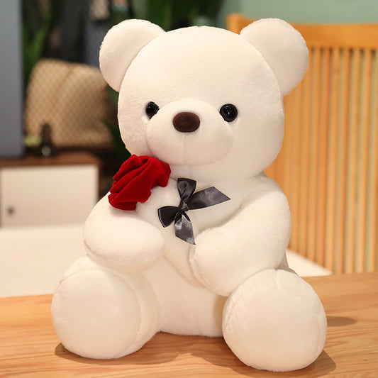 Cream teddy bear plush pillow with red flower and black bow tie, sitting