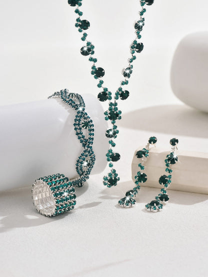 Jewelry set with necklace, bracelet, and earrings featuring green gemstones on a white background.