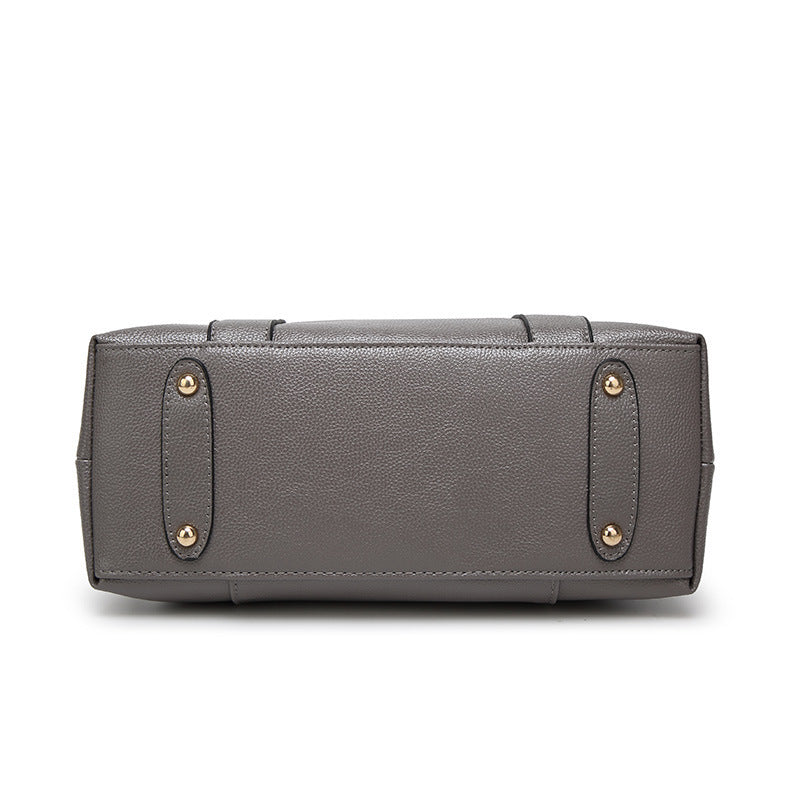 Gray handbag with gold accents on a white background