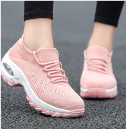 Pink athletic shoes with white soles on a gray background
