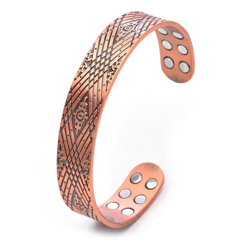 Copper bracelet with intricate patterns on a white background