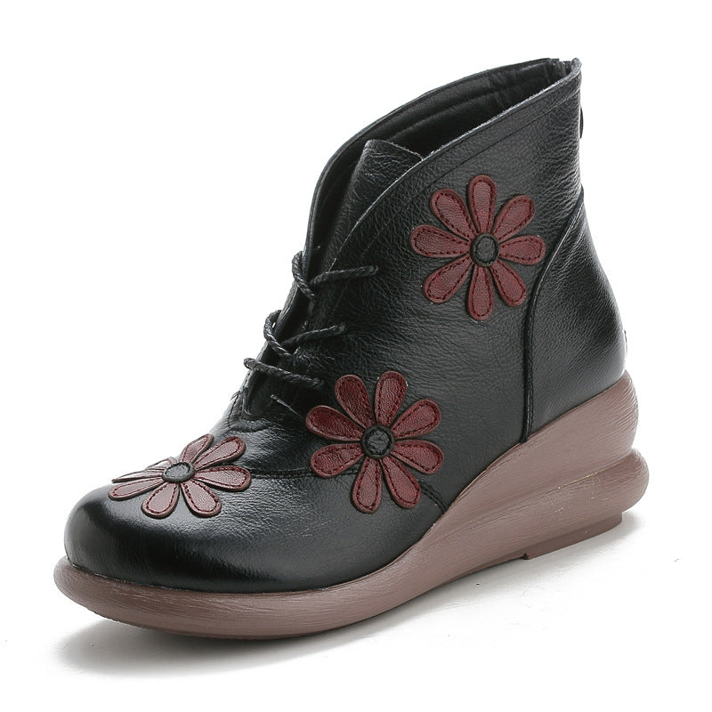 Black ankle boot with red floral patterns on a white background