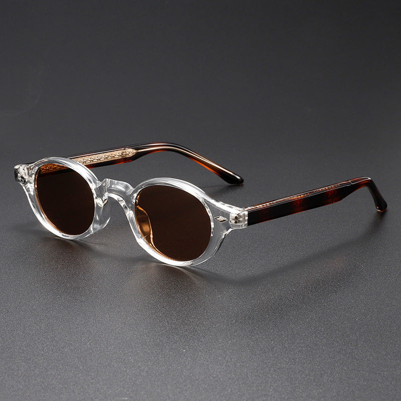 Sunglasses with clear frame and brown lenses on a gray background