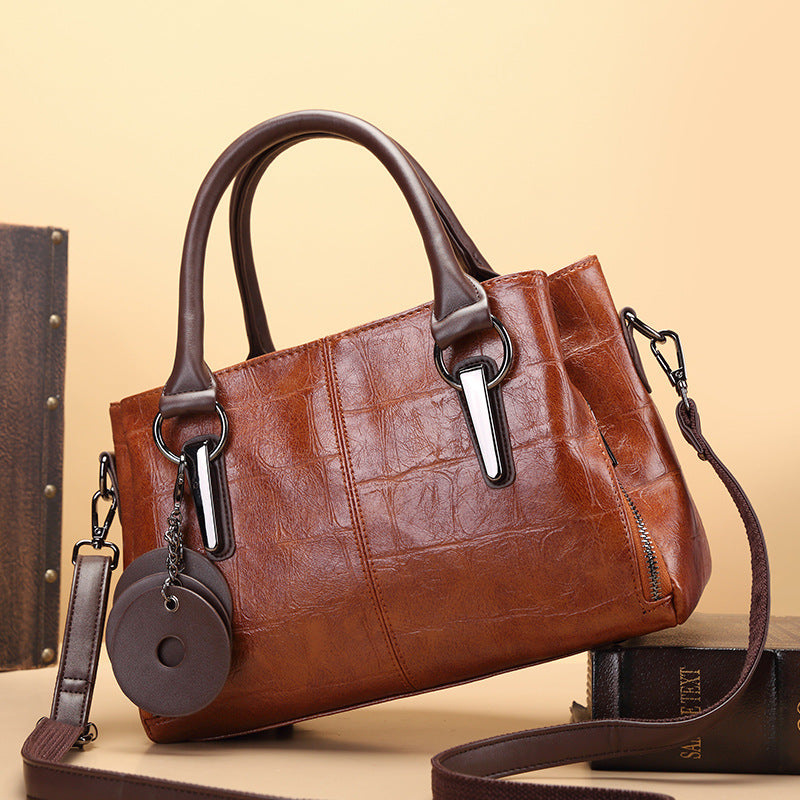 Brown retro large-capacity handbag with top handles, metal hardware, and long crossbody strap