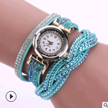 Turquoise bracelet with a watch face on a wrist against a white background