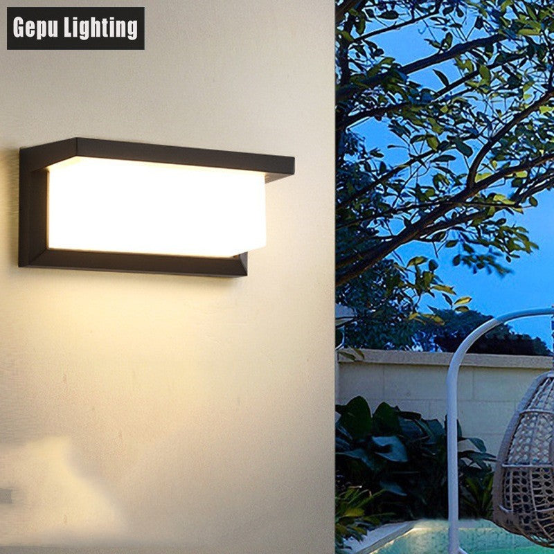 Outdoor wall lamp with black frame and glowing LED panel mounted on exterior wall