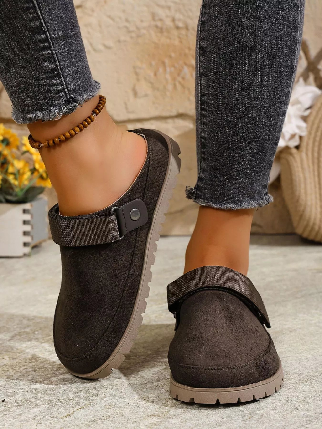 Dark gray round-toe slip-on flats with side strap and button detail on upper