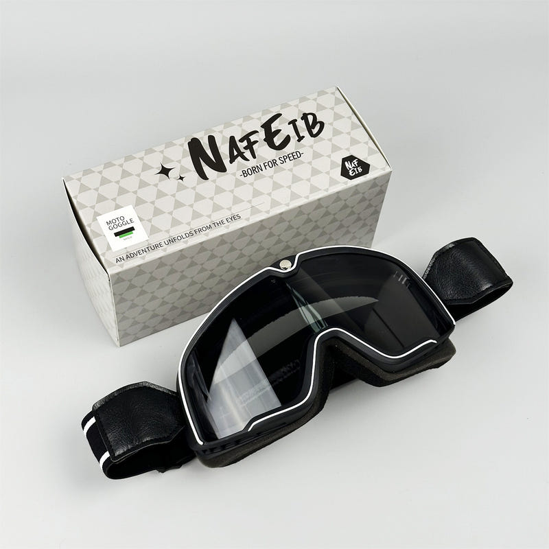 Sporty motorcycle goggles with black frame and clear anti-fog lens, wide strap