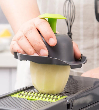 7-in-1 vegetable cutter holding a yellow food pusher over green cutting plate