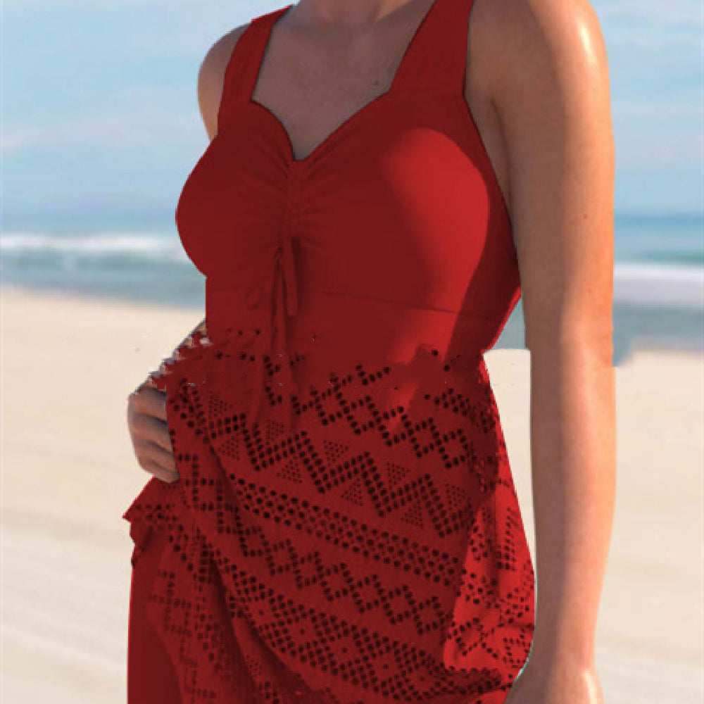 Person wearing a red dress with a black pattern on a beach
