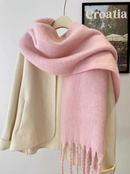 Pink scarf draped over a beige coat on a hanger with a 'Croatia' sign in the background.
