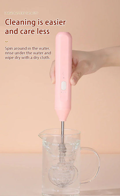 Pink wireless egg beater submerged whisk attachment in a measuring cup