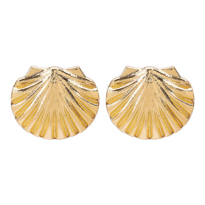 Gold shell-shaped earrings on a white background