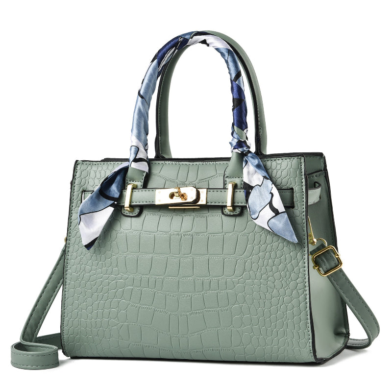 Green handbag with a decorative scarf on a white background