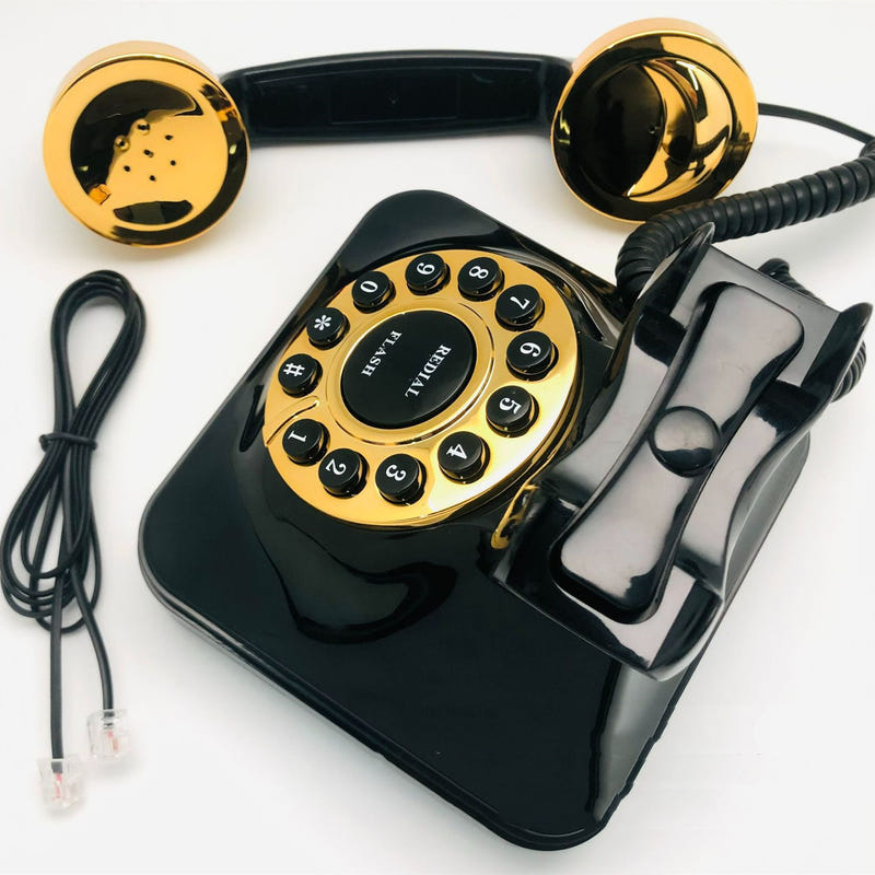 Black antique rotary telephone with gold dial, buttons, and handset cradle
